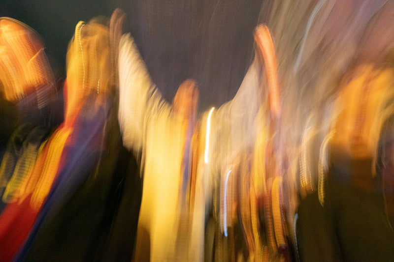 Abstract motion blur of a night crowd in gold, red and blue light