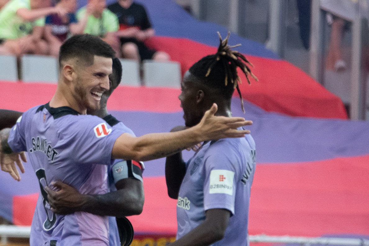 Two Athletic Club players embrace as they celebrate a goal