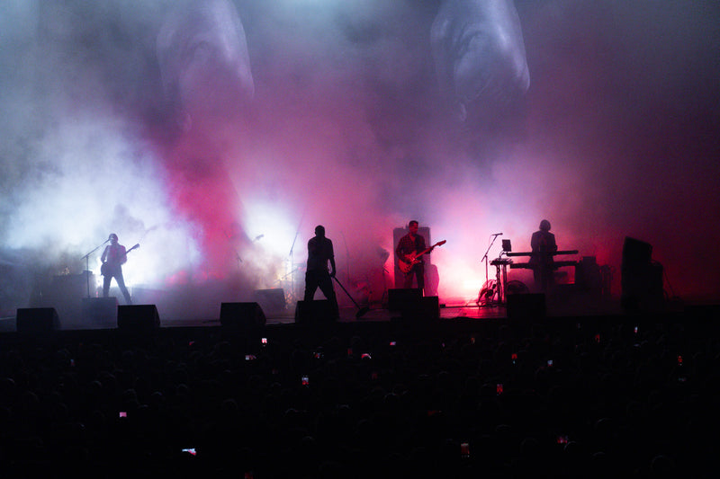Band in silhouette on stage in pink and purple haze during a concert