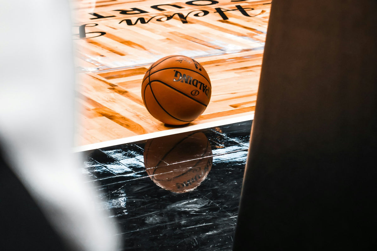 Basketball resting on the court of an indoor arena