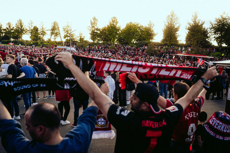 Bayer Leverkusen supporters raise their scarves outside the stadium