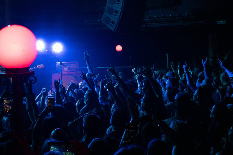 Concert crowd under blue light with a large red spherical lamp