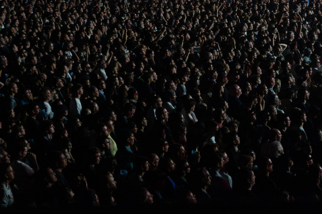 Dense dark concert crowd looking up toward the stage