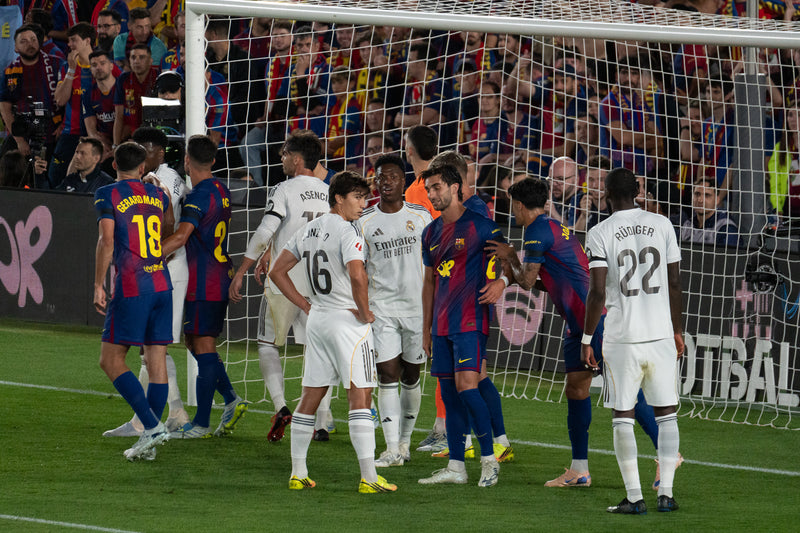 Barcelona and Real Madrid players jostle in the box before a corner during El Clasico