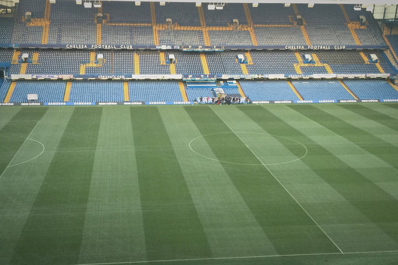 Empty Stamford Bridge pitch with Chelsea Football Club lettering on the stand opposite