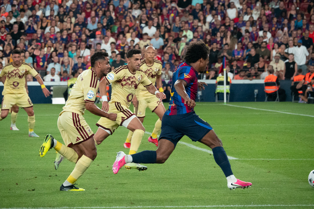 FC Barcelona player sprints forward with the ball as three defenders chase