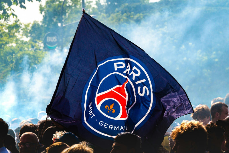 Paris Saint-Germain flag waved above a crowd of supporters