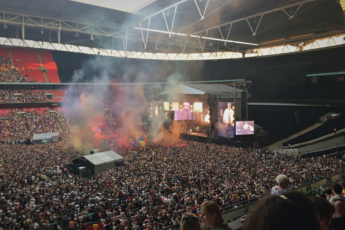 Wembley Stadium concert crowd with coloured smoke in front of the stage